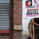 A protester holds up a sign with images of both Eric Garner and Michael Brown, both killed at the hands of police officers, during an August 2014 action on Staten Island in New York City.